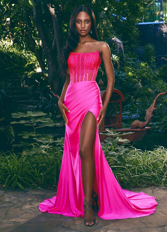 Elevate your style with the Ashley Lauren 11690 Sheer Crystal Corset Prom Dress. This stunning gown features a fitted jersey silhouette with a sheer corset bodice embellished with crystals, adding a touch of sparkle to your prom look. The flowing skirt is accented with a side slit for a modern and elegant touch. 