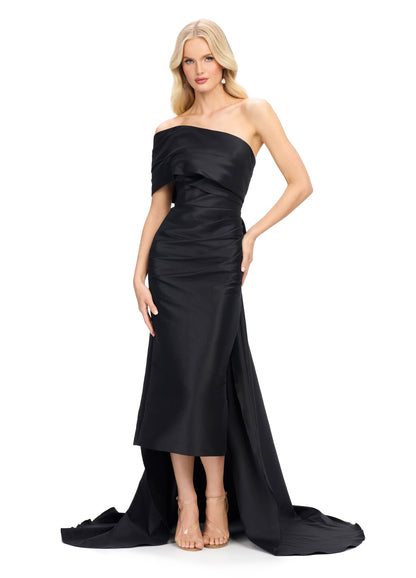 This Ashley Lauren 11727 one shoulder evening gown is a stunning choice for your next special event. The wide wrap strap and sheath design create a flattering silhouette, while the half bow in the back adds a touch of elegance. The overskirt with train adds drama and movement to the dress. Expertly designed for a sophisticated and memorable look.