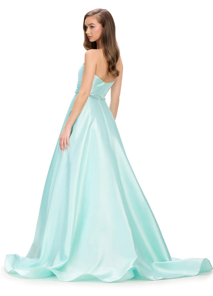 Elegant and sophisticated, the Ashley Lauren 11773 Strapless Ballgown is perfect for any formal occasion. The ruched bodice and crystal belt add subtle details, while the strapless design allows for comfortable wear. Made with high quality materials, this dress is sure to make a statement.