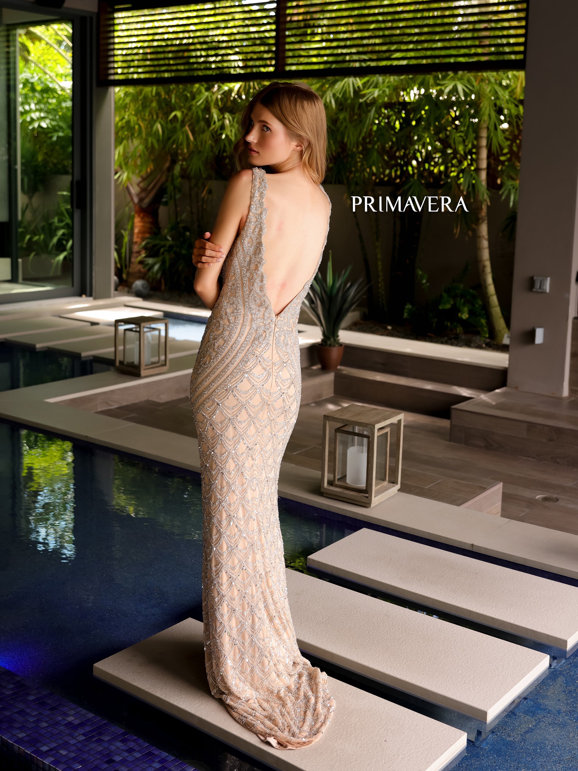 Get ready to turn heads in the elegant Primavera Couture 12102 Long Beaded Formal Evening Dress! With a stunning sequin design and scallop V neck, this backless prom gown will make you stand out from the crowd. Get ready to feel confident and glamorous at any formal event.  Sizes: 000-18  Colors: Coral, Nude/Silver
