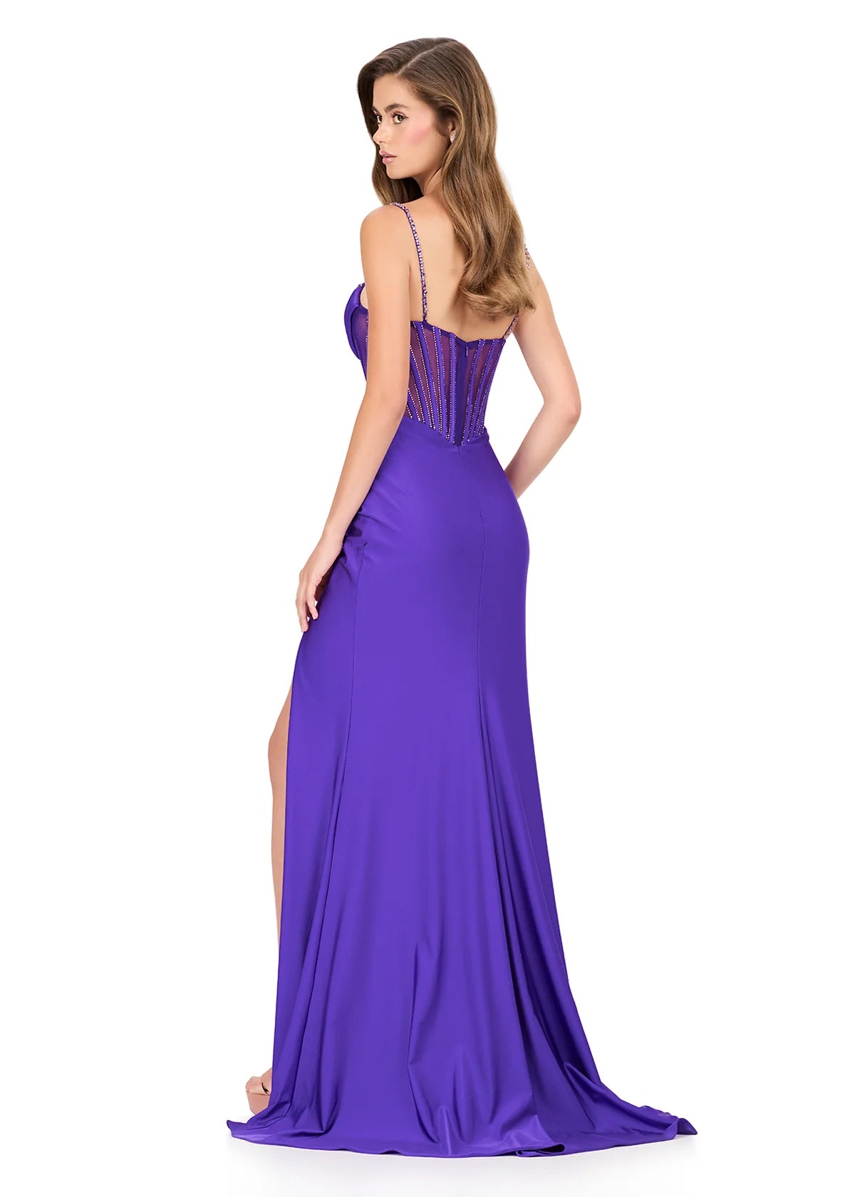 Step into sophistication with this sleek and elegant jersey gown, ASHLEYlauren Style 12173. Featuring a beaded bustier-style bodice with delicate spaghetti straps, this fitted dress highlights your figure with a ruched waist and flattering draped skirt. The corset detailing adds structure and sparkle, while the sweeping train ensures a glamorous finish. Perfect for prom, pageant, or any formal event, this gown brings modern allure and timeless elegance together.

Available in Emerald, Purple, Red, Black, Fu