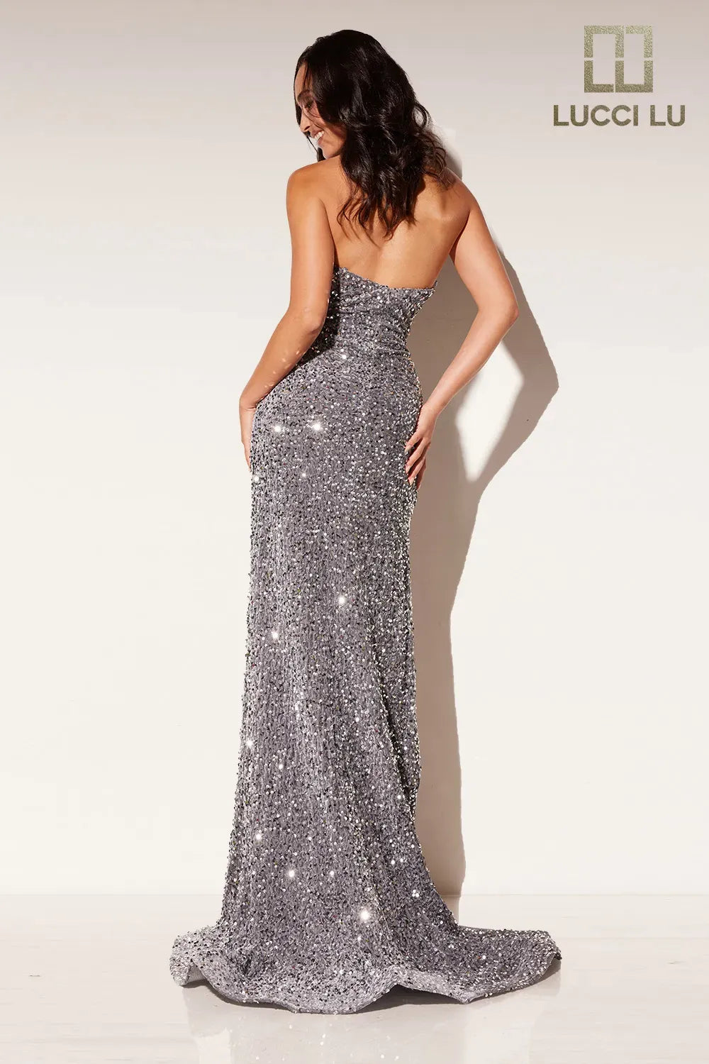 Step into the spotlight with the Lucci Lu Sequin Velvet Strapless Formal Pageant Dress. This stunning gown features a crystal-embellished bodice and a high slit for added drama. The strapless peak point neckline adds a touch of elegance, making it the perfect choice for your next formal event or prom night.  Sizes: 0-18  Colors: Purple, Magenta, Royal Blue, Silver