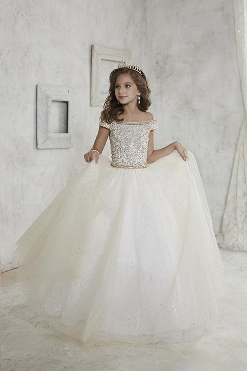 Get your little princess ready for the pageant stage with the Tiffany Princess 13457 Girls Long Pageant Dress. The beautiful off-the-shoulder style is adorned with Detailed beading that add a touch of sparkle to the bodice, while the fully gathered glitter tulle skirt adds a touch of shimmer. The lace-up back ensures a perfect fit for your little one. this dress is sure to make her shine on stage. 