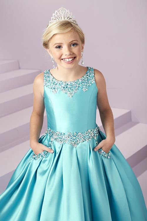 Expertly designed for the modern princess, the Tiffany Princess 13485 Girls Pageant Dress is a stunning Mikado A Line masterpiece. Embellished with intricate beadwork and featuring convenient pockets, this open back ball gown will make any young lady feel like royalty. <span data-mce-fragment="1">A beaded scoop neckline and waistband showcase this adorable gown. Complete with a box pleated, a-line mikado skirt with front Pockets, and an open back with lace-up.</span>