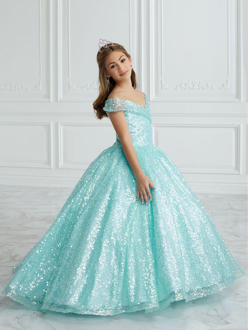 This stunning Tiffany Princess 13679 pageant dress features a dazzling sequin design, off the shoulder neckline, and a full ball gown silhouette, making your little one feel like royalty. Perfect for formal events and pageants, this dress is both elegant and eye-catching.