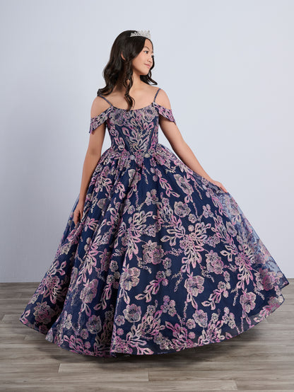 Be the belle of the ball in the Tiffany Princess 13794 Glitter Floral Girls Pageant Dress. This stunning off the shoulder ballgown features a corset bodice and a flowing cape for added drama. The glittering floral details will make you stand out from the crowd. Perfect for any pageant or special occasion.

Sizes: 2-16

Colors: Navy/Multi, Pink/Multi