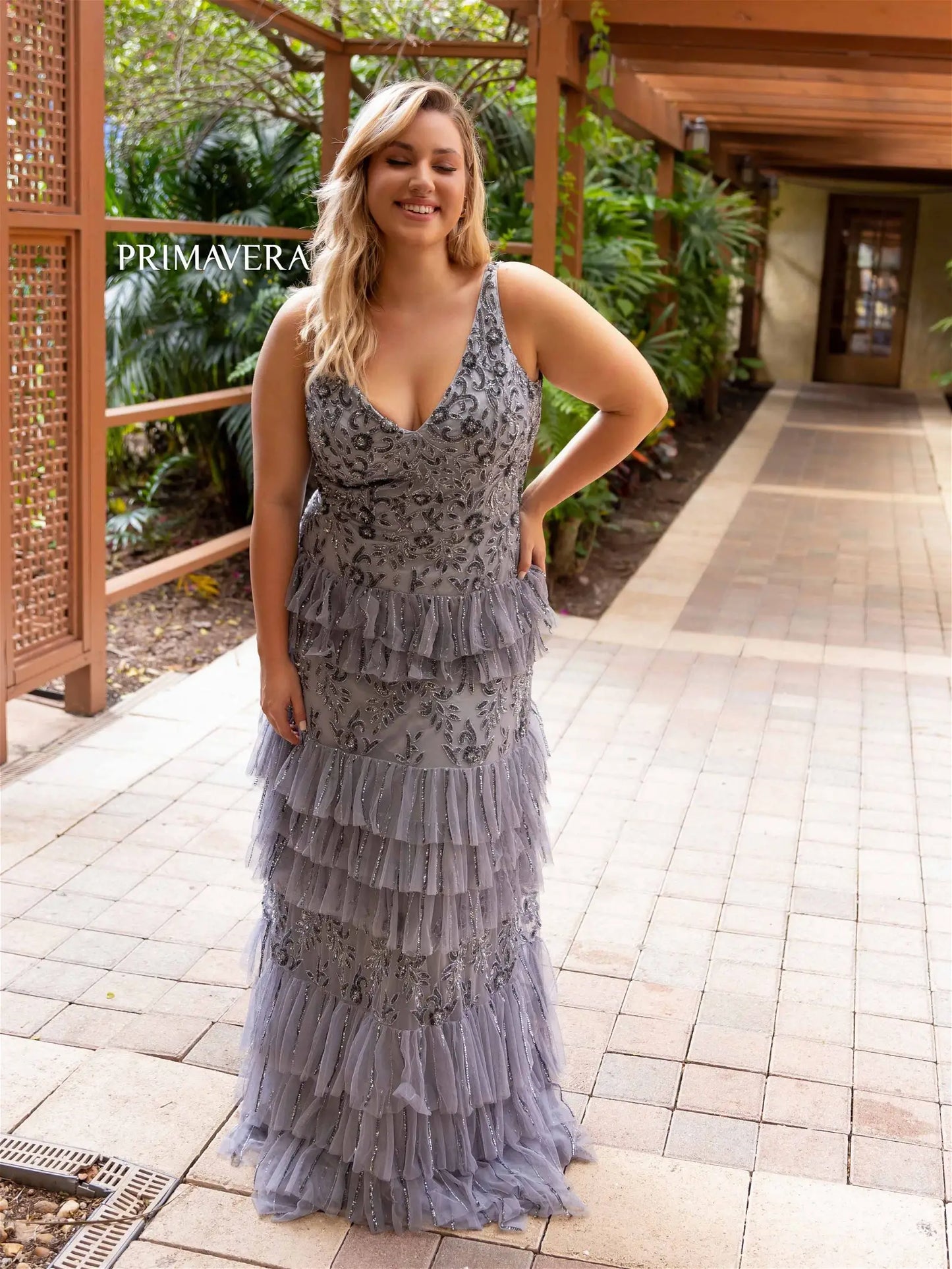 This elegant Primavera Couture 14052 prom dress is designed to showcase your curves with its long, fitted silhouette. The sequin detailing adds a touch of glamour, while the tiered skirt adds movement and volume. Perfect for formal occasions, this plus size gown is sure to turn heads.