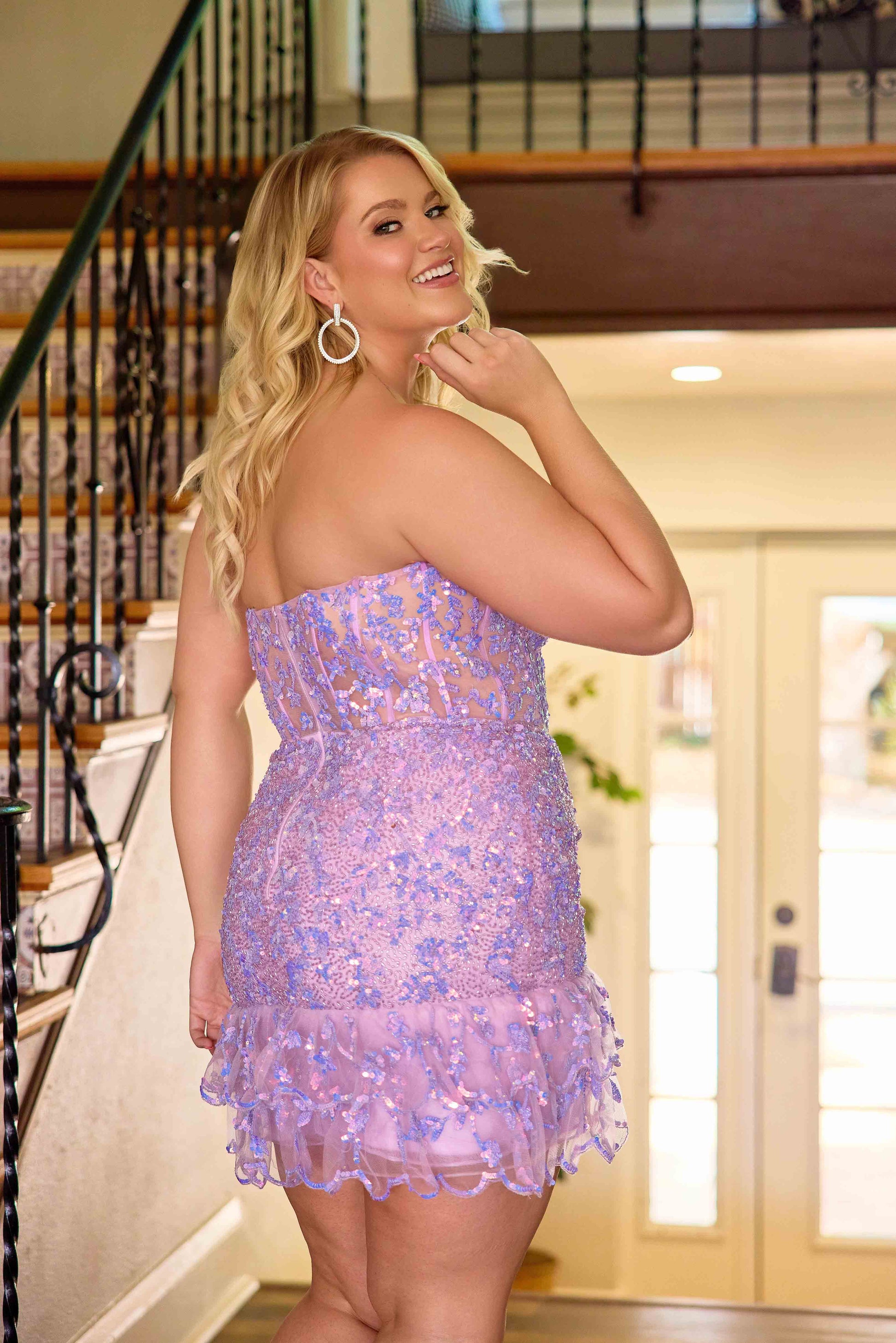 The Primavera Couture 14089 Plus Size Homecoming Dress combines sophisticated design with flattering fit. Featuring a sequin-embellished bodice and a delicate ruffle hem, this gown accentuates curves elegantly. The sheer corset detail adds a modern touch while providing structured support, making it an ideal choice for formal events and cocktail parties. Crafted to enhance confidence and style, this dress offers a stunning silhouette for any plus-size wearer seeking both glamour and comfort.

Sizes: 14W-24W