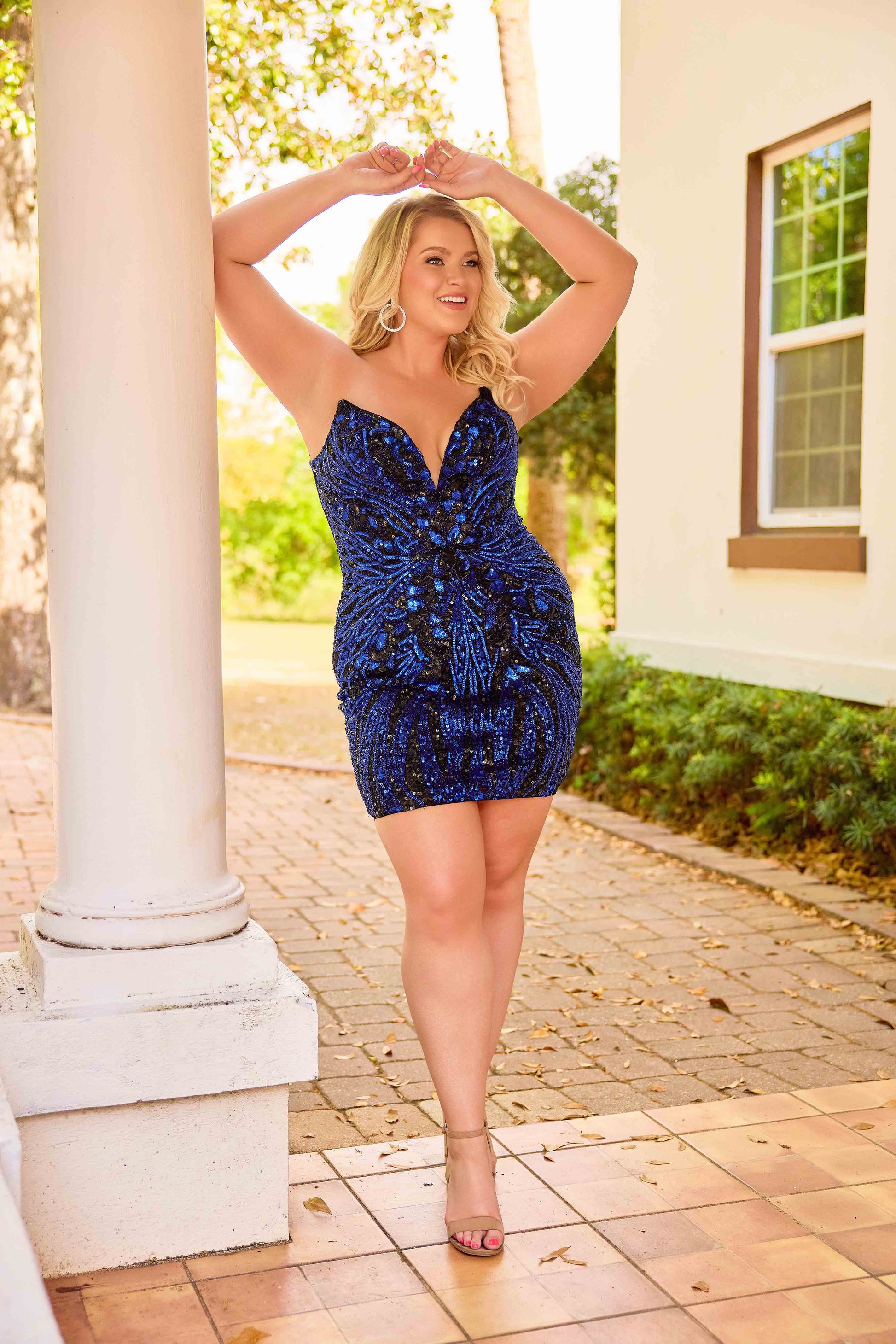 The Primavera Couture 14099 short plus-size homecoming dress combines elegance with comfort through its expertly crafted beaded sequin design. Featuring a strapless, V-neck silhouette with a corset back, this formal cocktail gown offers both support and a flattering fit. Ideal for homecoming or special occasions, its sparkling embellishments ensure you stand out, while the short length provides ease of movement and a modern touch to classic formalwear.

Sizes: 14W-24W

Colors: Black/Fuchsia, Black/Gold, Bla