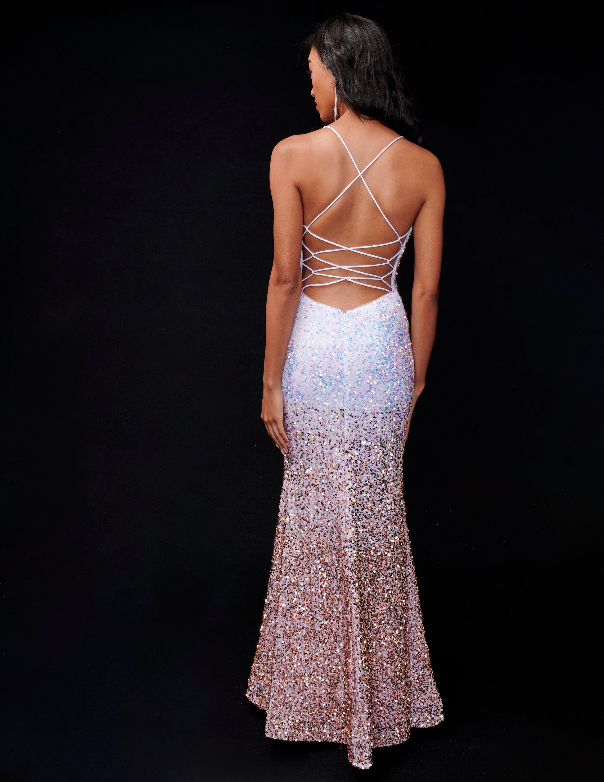 Get ready to shine in the stunning Nina Canacci 1554 Prom Dress! The velvet sequin ombre design adds a touch of glamour, while the fitted silhouette and slit backless corset accentuate your curves. Perfect for any formal occasion, this gown will make you stand out with its elegant and stylish look.