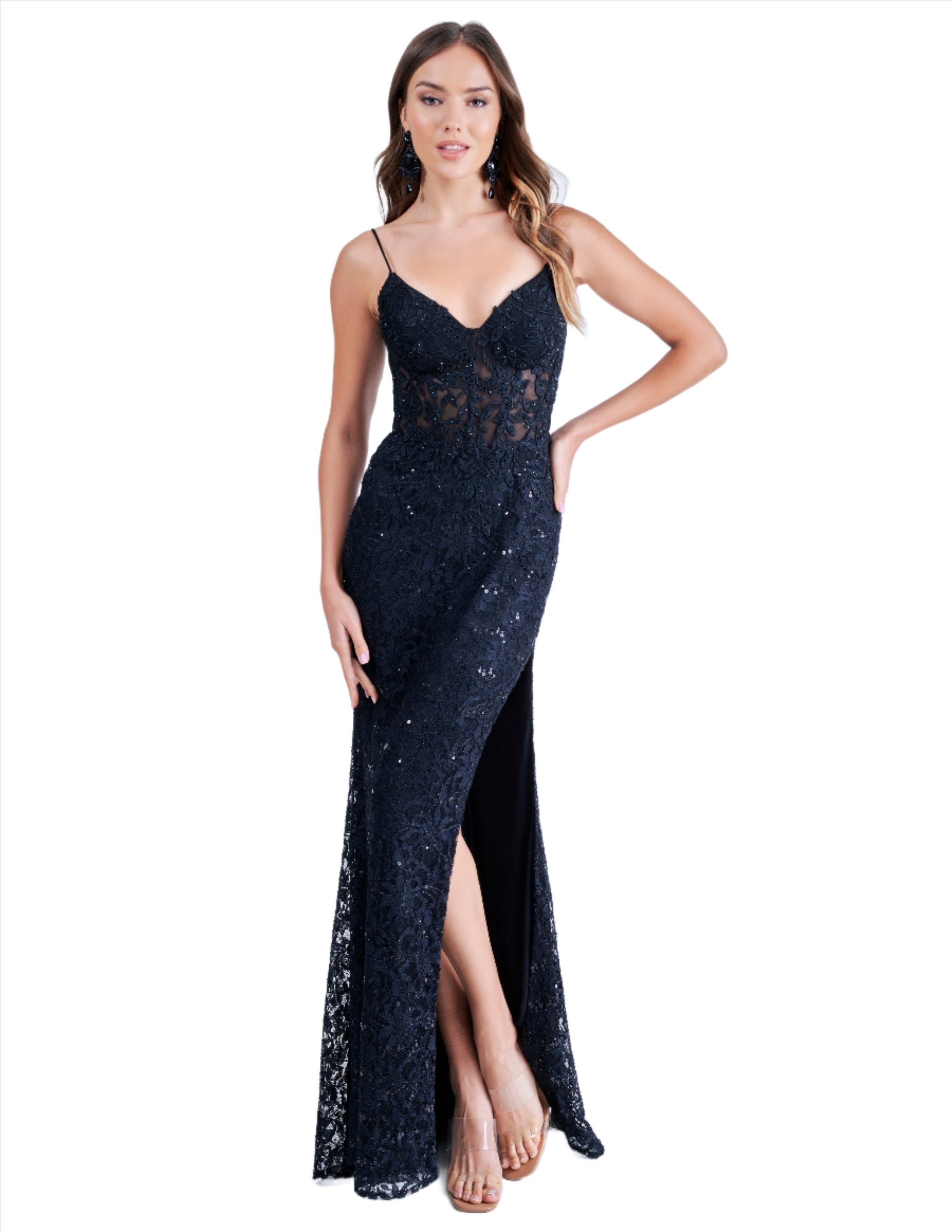 Elevate your evening look with the Nina Canacci 1568 formal dress. Featuring a sheer lace corset and a striking sequin crystal V neck, this dress exudes elegance and sophistication. The corset detail cinches the waist for a flattering silhouette, while the slit adds a touch of sultry appeal. Perfect for prom or any formal event.