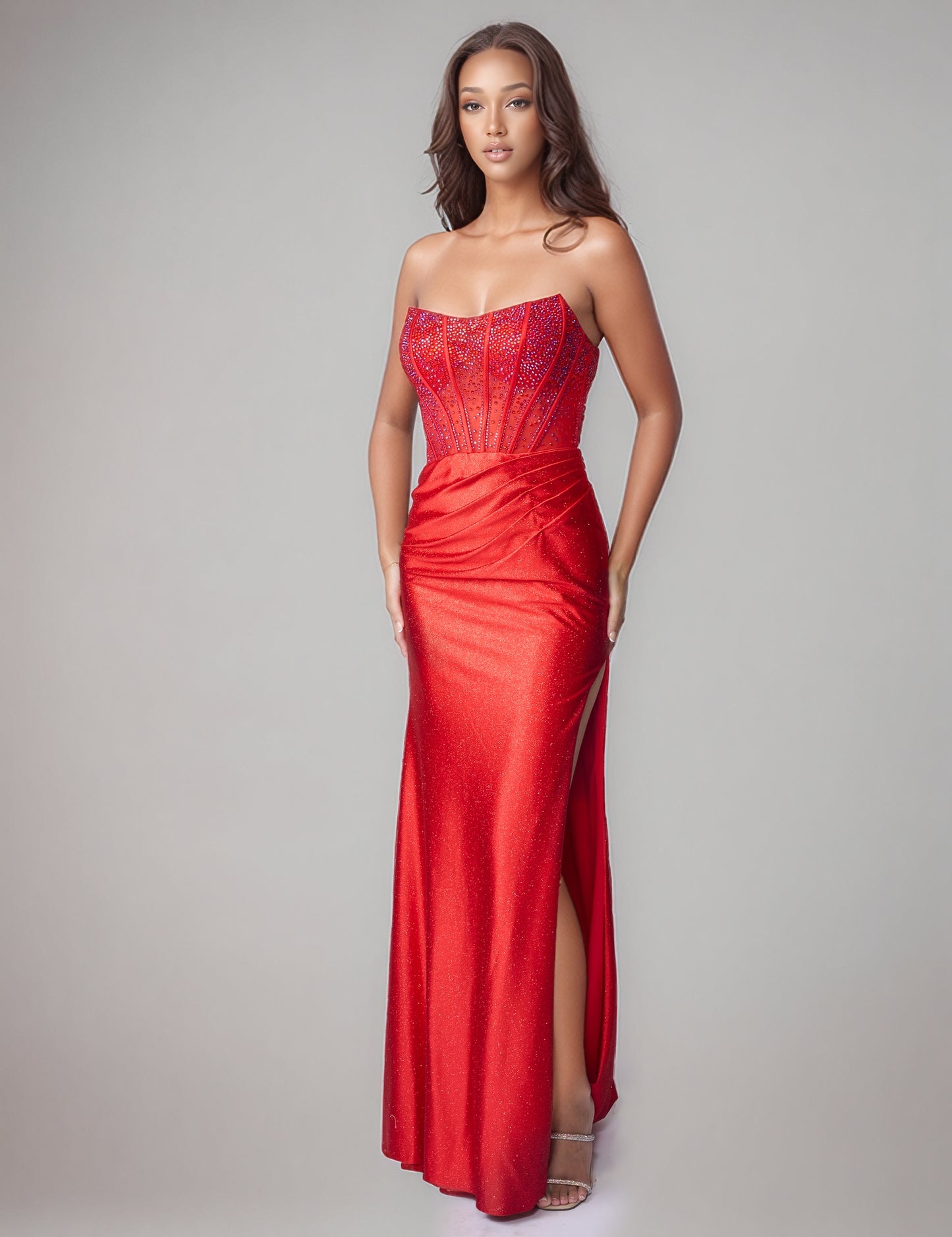 Elevate your prom night with the Nina Canacci style 1605 Crystal Corset Prom Dress. This stunning formal gown features a sheer crystal-embellished corset bodice that commands attention, paired with a luxuriously ruched jersey skirt. The strapless design showcases a graceful scoop neckline, while a dramatic side slit adds movement and sophistication. Perfect for those seeking timeless elegance with modern glamour.

Sizes: 0-10

Colors: Red, Teal, Black
