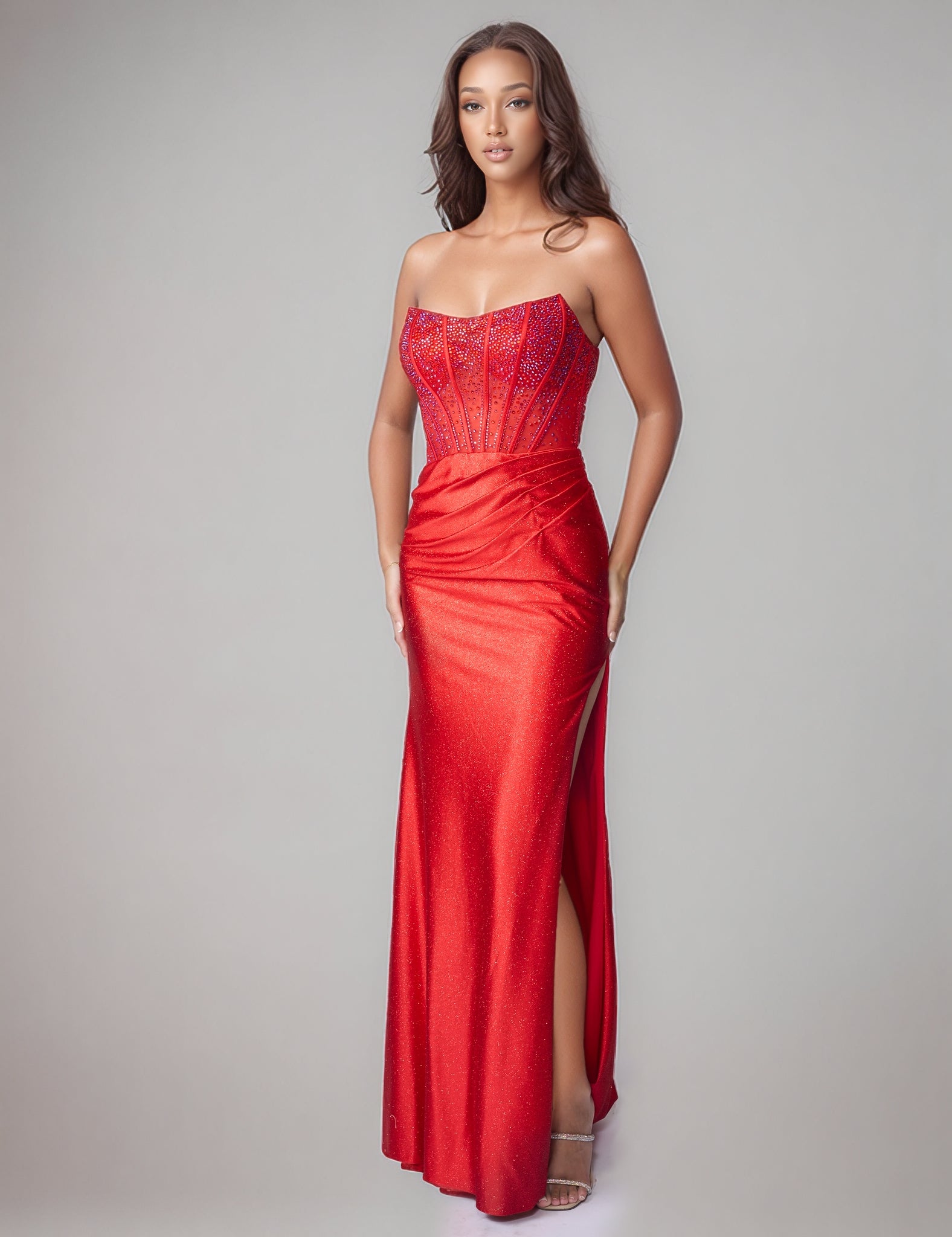 Elevate your prom night with the Nina Canacci style 1605 Crystal Corset Prom Dress. This stunning formal gown features a sheer crystal-embellished corset bodice that commands attention, paired with a luxuriously ruched jersey skirt. The strapless design showcases a graceful scoop neckline, while a dramatic side slit adds movement and sophistication. Perfect for those seeking timeless elegance with modern glamour.

Sizes: 0-10

Colors: Red, Teal, Black