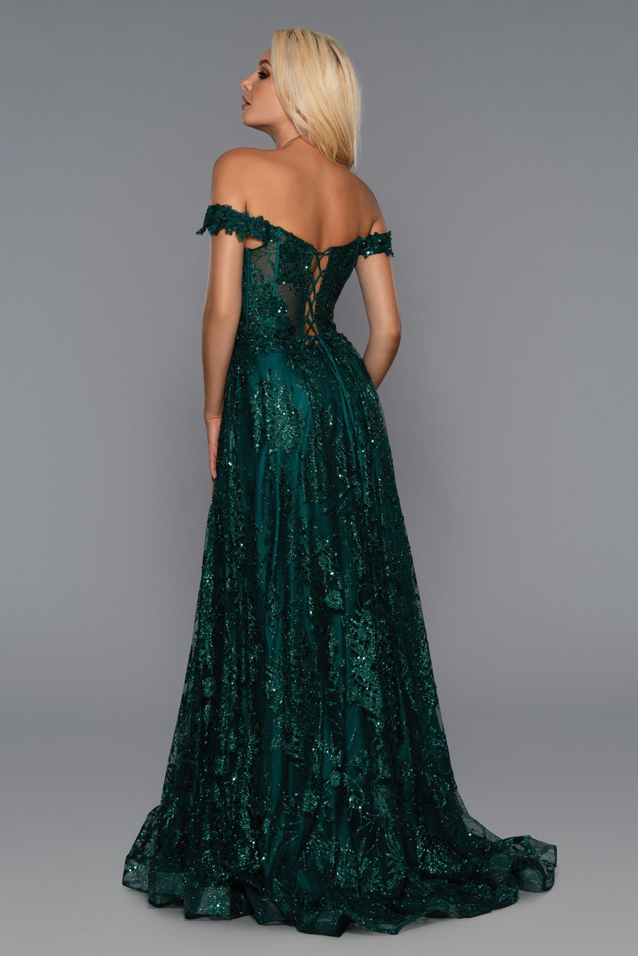 Stella Couture 21064 is a long a line formal prom and pageant dress. Featuring a plunging deep V Neckline with a sheer embellished bodice and off the shoulder straps. high slit in skirt. lace up corset back. Great for any formal event.  Available Size: 0-18  Available Color: Emerald, Rose Gold, Royal
