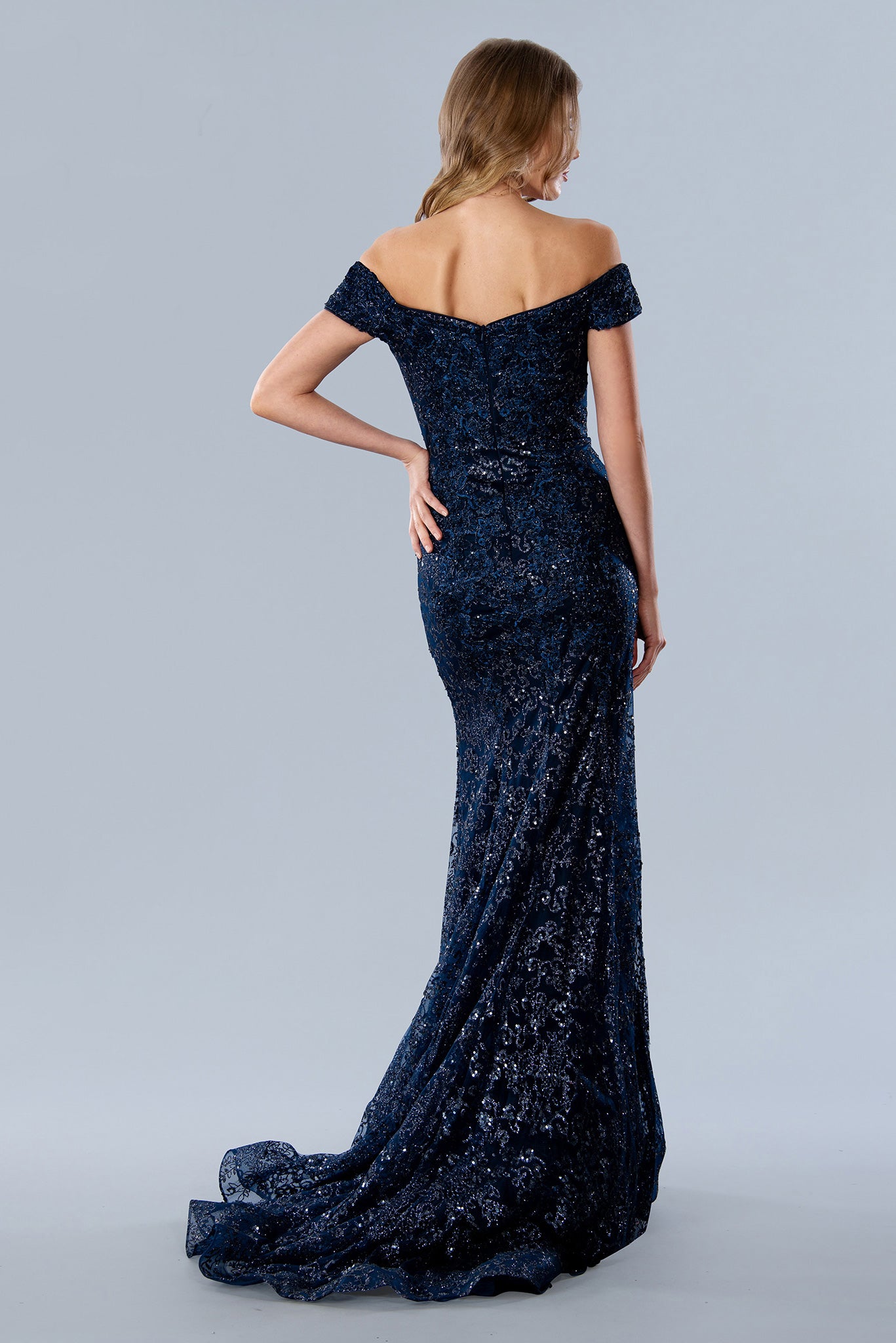 Stella Couture 22069 shimmer Glitter dress offers a stunningly glamorous look for prom. The fitted silhouette and off-the-shoulder design create an elegant, flattering shape, while sparkling glitter fabric adds a touch of glamour. Perfect for making a statement at your prom or special event. 