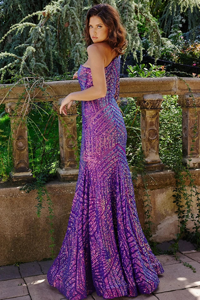 Jovani 24098 Iridescent Fully Line Sequin Long Sleeve One Shoulder Mermaid Prom Dress. This elegant prom dress by Jovani will make you the belle of the ball. Intricately crafted with a one shoulder neckline and fully lined iridescent sequin material, this mermaid silhouette creates a stunning and glamorous look. Perfect for making unforgettable memories.