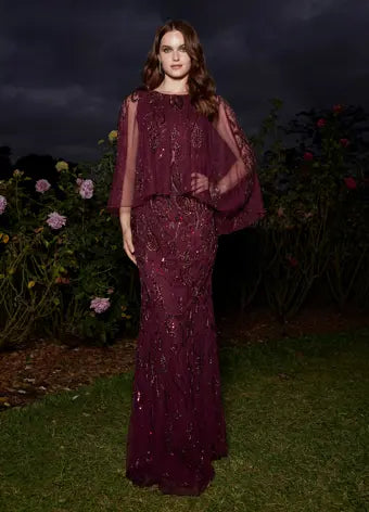 Ashley Lauren 11214 Fully Hand Beaded Crew Neckline High Back Overlay Fitted Evening Dress. A timeless evening gown complete with a sheer overlay. This gown has a sequin motif that sparkles throughout the gown and overlay. Talk about elegant!