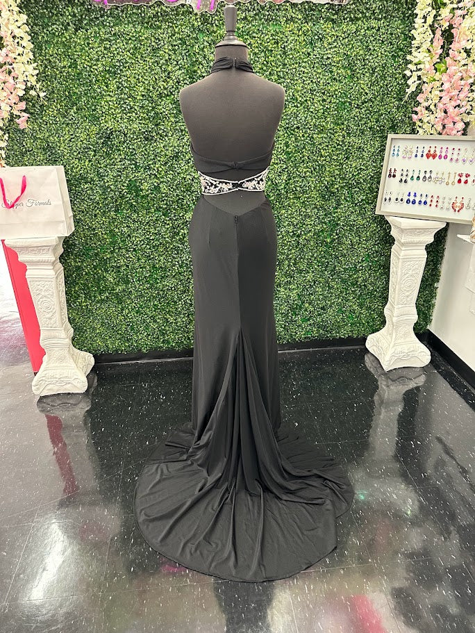This Johnathan Kayne gown in size 4 features a sleek black fitted silhouette that elegantly contours the body. The high slit adds a dramatic touch, while the cut-out back offers a modern, alluring detail. Accentuated with a crystal-embellished waist, this prom dress combines sophistication with a hint of sparkle, perfect for making a confident statement at any formal event.

Size: 4

Color: Black