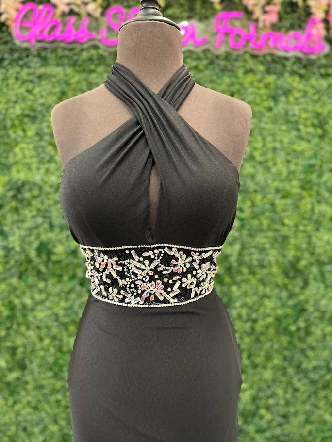 This Johnathan Kayne gown in size 4 features a sleek black fitted silhouette that elegantly contours the body. The high slit adds a dramatic touch, while the cut-out back offers a modern, alluring detail. Accentuated with a crystal-embellished waist, this prom dress combines sophistication with a hint of sparkle, perfect for making a confident statement at any formal event.

Size: 4

Color: Black