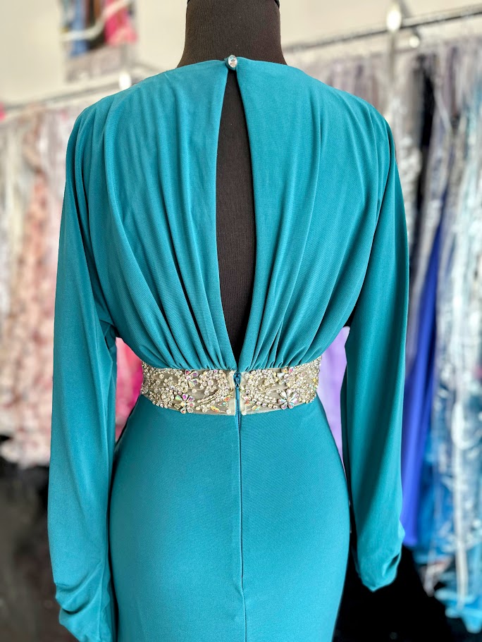 Elevate your evening with the Johnathan Kayne 2685 long sleeve formal gown in a stunning teal hue. This size 4 dress features a high slit that adds a touch of allure, while delicate crystal and sheer beading embellishments create an exquisite, sophisticated shimmer. Perfect for making a graceful statement at any formal event.

Size: 4

Color: Teal