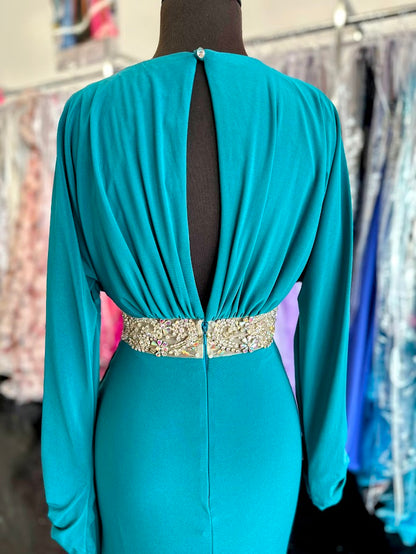 Elevate your evening with the Johnathan Kayne 2685 long sleeve formal gown in a stunning teal hue. This size 4 dress features a high slit that adds a touch of allure, while delicate crystal and sheer beading embellishments create an exquisite, sophisticated shimmer. Perfect for making a graceful statement at any formal event.

Size: 4

Color: Teal