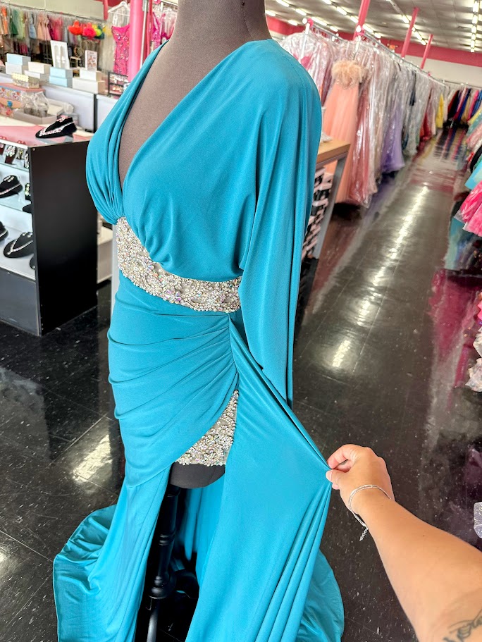Elevate your evening with the Johnathan Kayne 2685 long sleeve formal gown in a stunning teal hue. This size 4 dress features a high slit that adds a touch of allure, while delicate crystal and sheer beading embellishments create an exquisite, sophisticated shimmer. Perfect for making a graceful statement at any formal event.

Size: 4

Color: Teal