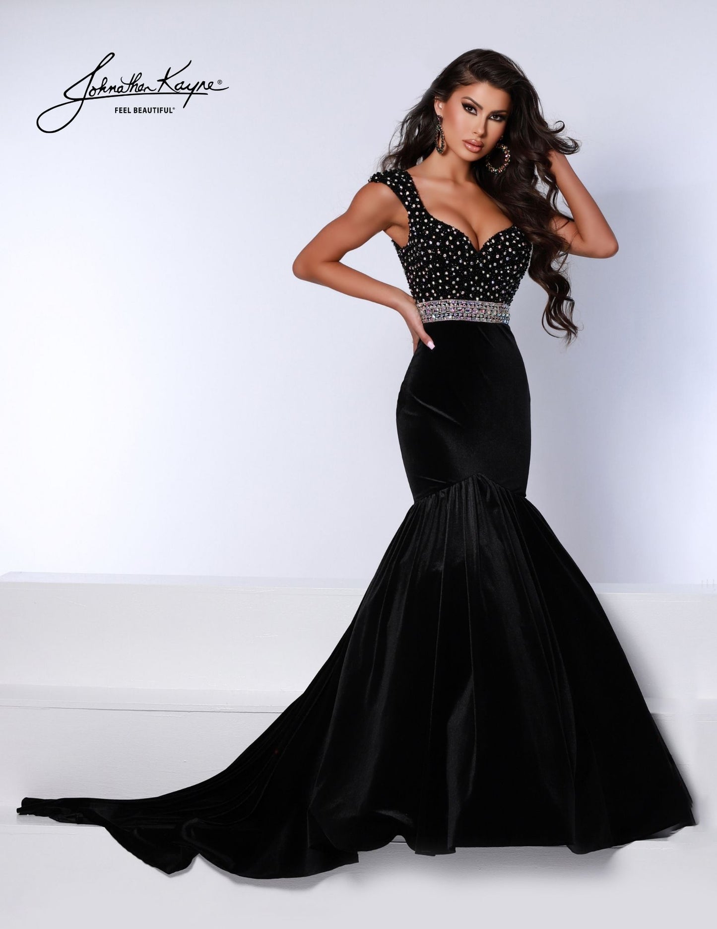 Introducing the Johnathan Kayne 2724 dress; a stunning evening gown featuring a fitted velvet bodice and mermaid skirt. Luxuriously crafted with a hot stone embellishment, it is sure to turn heads at any special event. The look is finished with an eye-catching crystal belt for a show-stopping finish.  Sizes: 00,0,2,4,6,8,10,12,14,16  Colors: Black, Red, White, Royal 