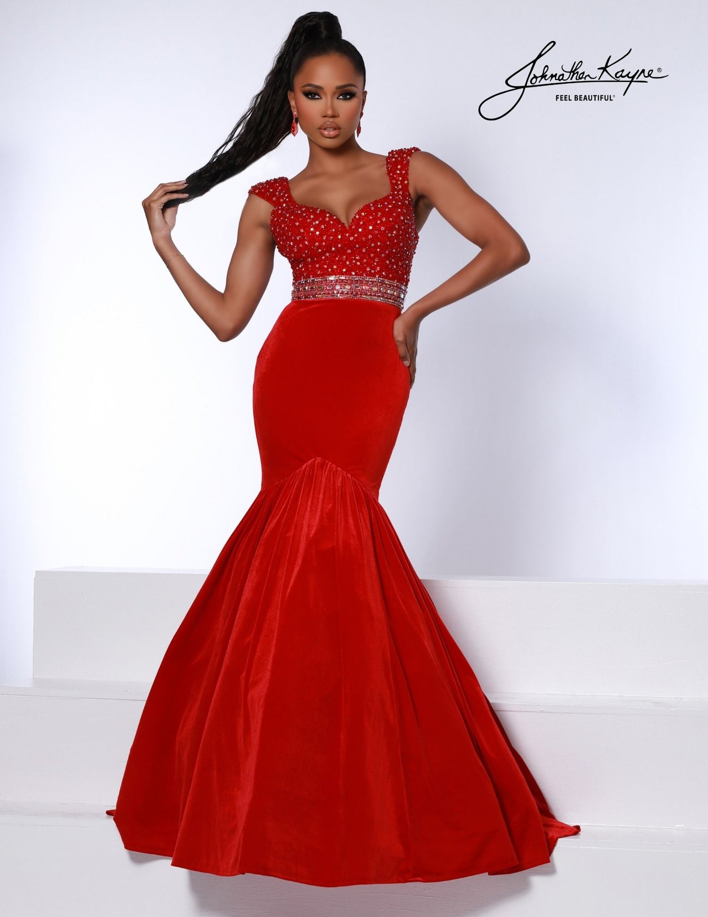 Introducing the Johnathan Kayne 2724 dress; a stunning evening gown featuring a fitted velvet bodice and mermaid skirt. Luxuriously crafted with a hot stone embellishment, it is sure to turn heads at any special event. The look is finished with an eye-catching crystal belt for a show-stopping finish.  Sizes: 00,0,2,4,6,8,10,12,14,16  Colors: Black, Red, White, Royal 
