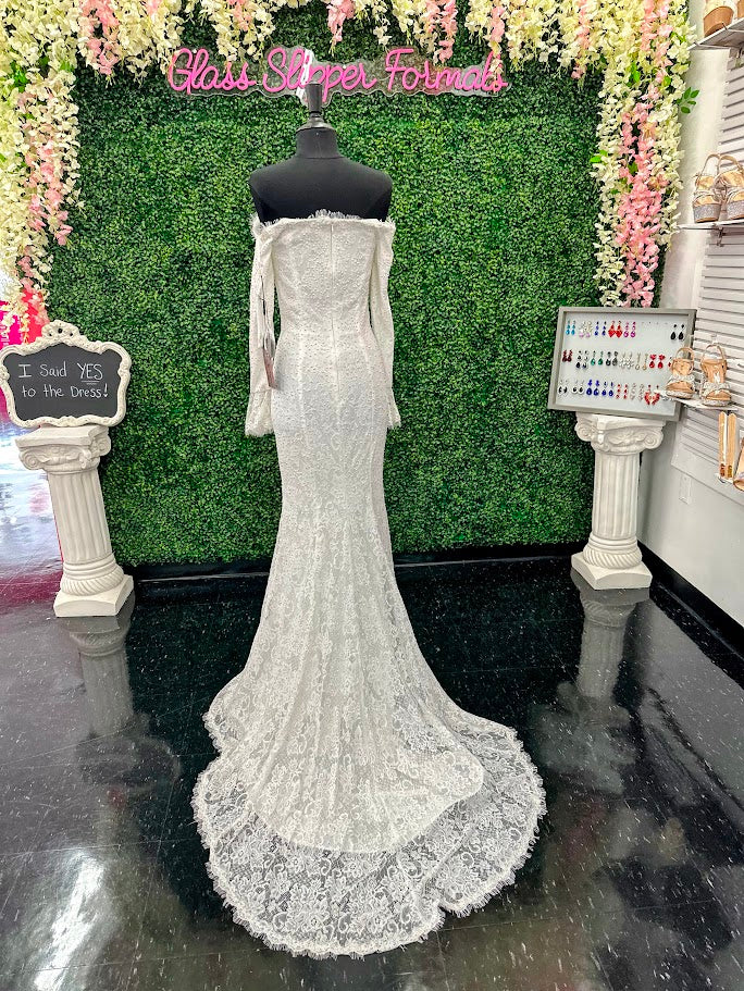 This exquisite Johnathan Kayne gown in size 4 features a long, fitted silhouette crafted from delicate white lace. Designed with an off-the-shoulder neckline and long sleeves ending in elegant ruffle cuffs, it offers a refined and sophisticated look. The dress is adorned with AB crystals that add subtle sparkle, while the eyelash lace edges and flowing train enhance its graceful presence, making it an ideal choice for pageants or formal events.

Size: 4

Color: White