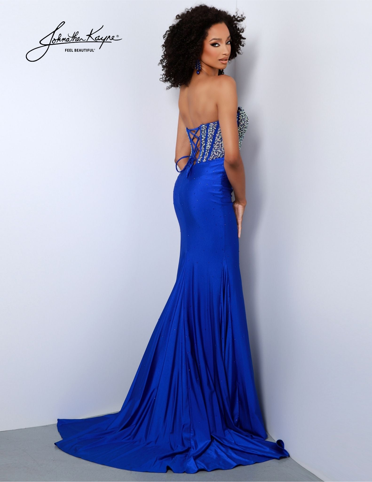 This Johnathan Kayne 2820 Long Formal Gown is perfect for the special occasion. The sparkling beaded corset showcases a sophisticated silhouette and the long slit train adds an air of drama. Perfect for pageants, prom, and more!