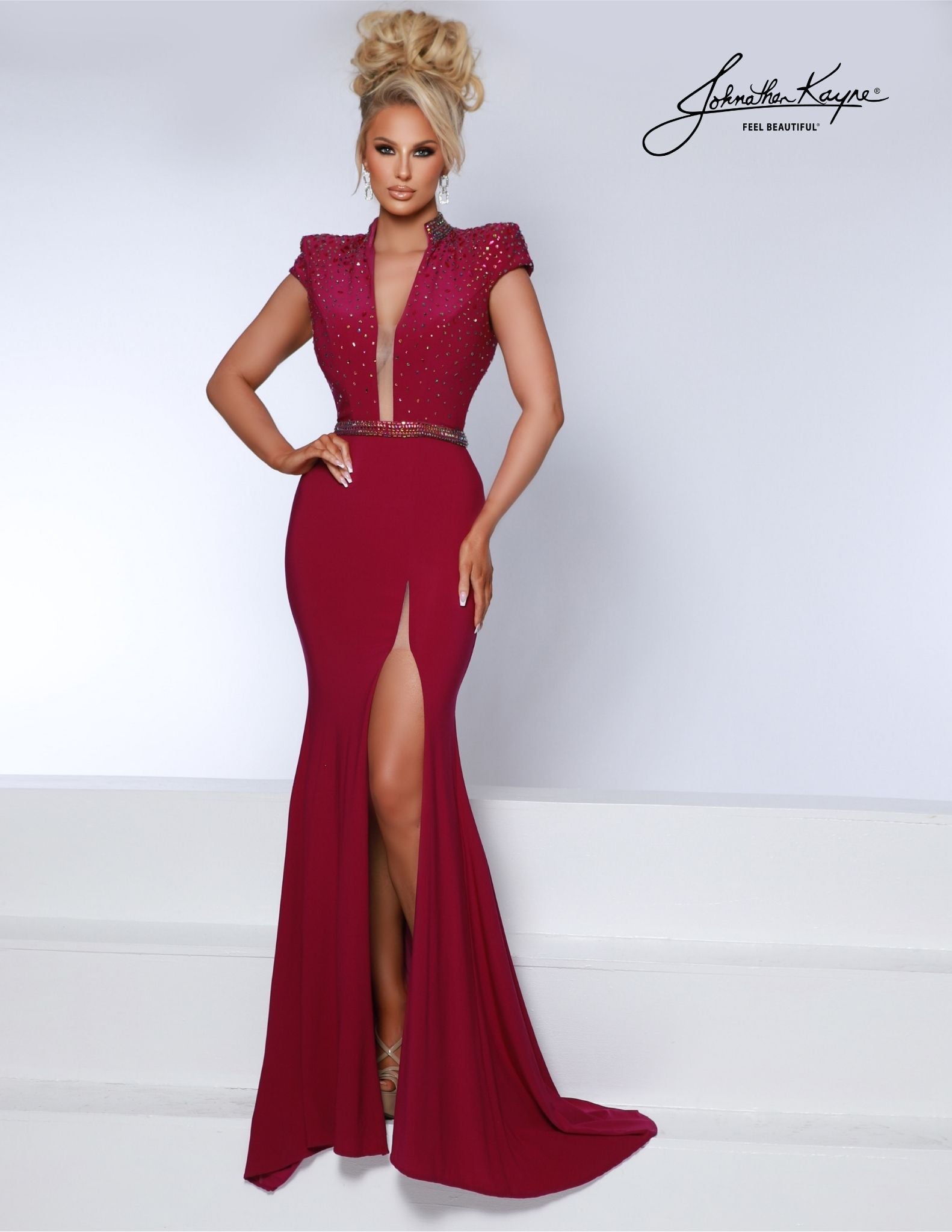This Johnathan Kayne 2849 maxi dress is perfect for formal occasions. Crafted from luxurious jersey, the mermaid silhouette and low neckline offers timeless elegance, while draped shoulder pads adds subtle detail. A dramatic side slit completes the look of this sophisticated gown. Leave a lasting impression! This matte jersey gown features the tempting low neckline, shoulder pads, and daring slit that promises to captivate and enthrall.