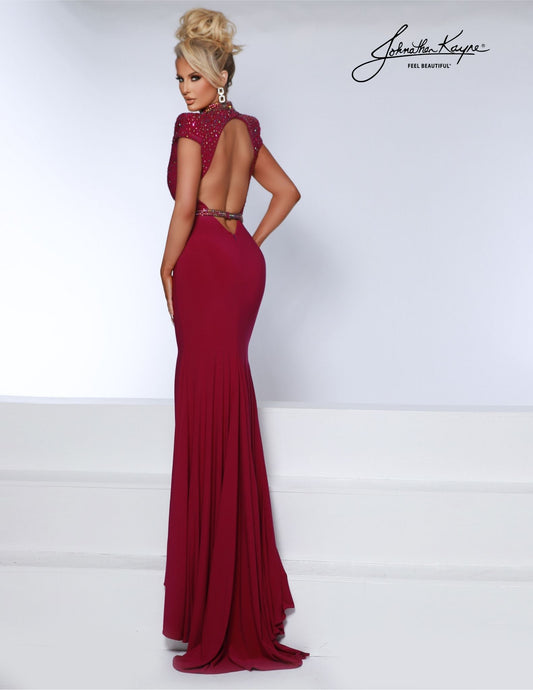 This Johnathan Kayne 2849 maxi dress is perfect for formal occasions. Crafted from luxurious jersey, the mermaid silhouette and low neckline offers timeless elegance, while draped shoulder pads adds subtle detail. A dramatic side slit completes the look of this sophisticated gown. Leave a lasting impression! This matte jersey gown features the tempting low neckline, shoulder pads, and daring slit that promises to captivate and enthrall.