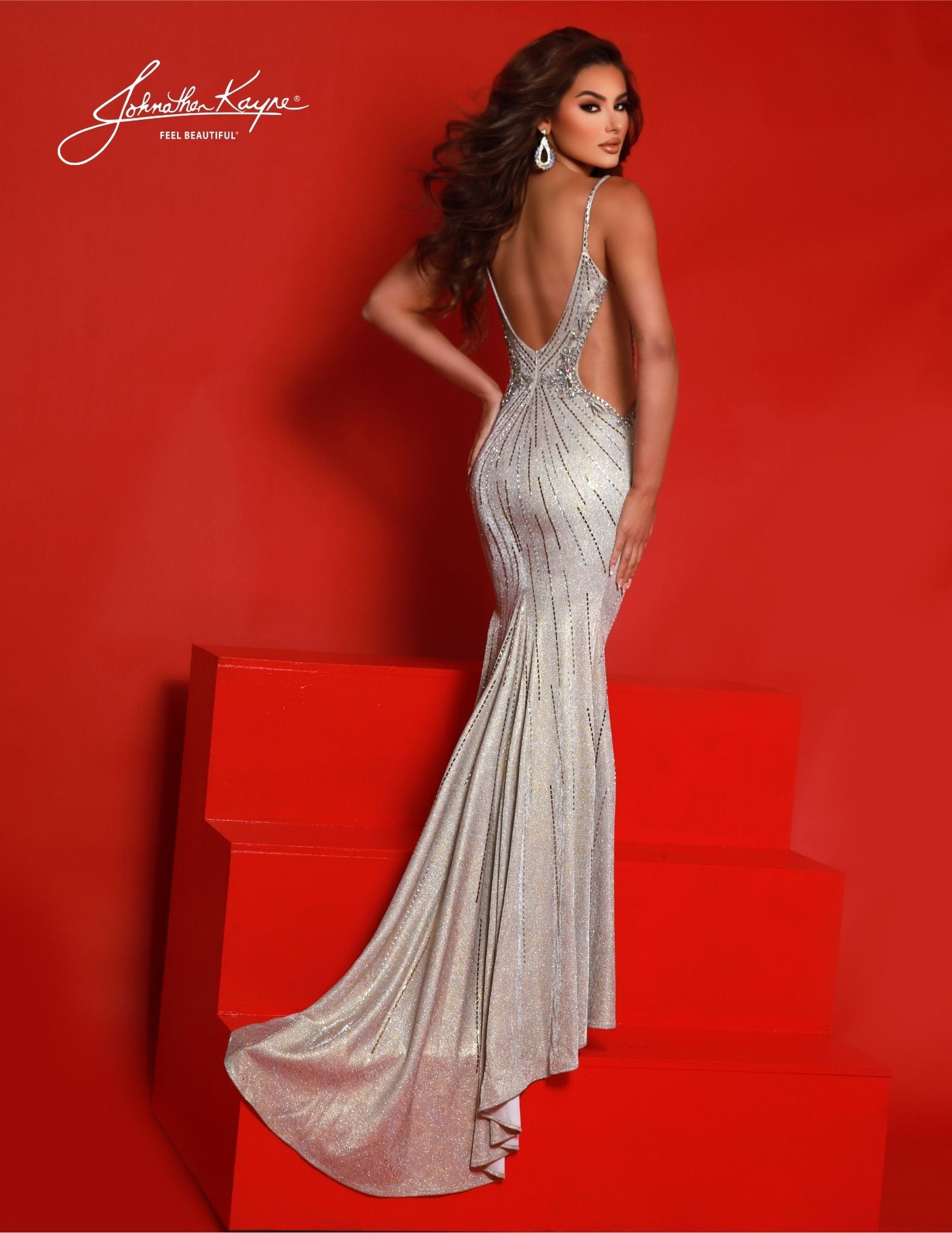 Look stunning in this metallic Johnathan Kayne 2850 formal dress. This floor-length gown features a V-Neck neckline, side cut outs, backless design, maxi slit, glitter knit mesh, and is perfect for any special event. Make a lasting impression in this beautiful gown! Prepare for an unforgettable night of luminance with our metallic glitter knit gown. The sultry sheer side cutouts, daring slit, and radiant glitter knit create a look that's both memorable and timeless.