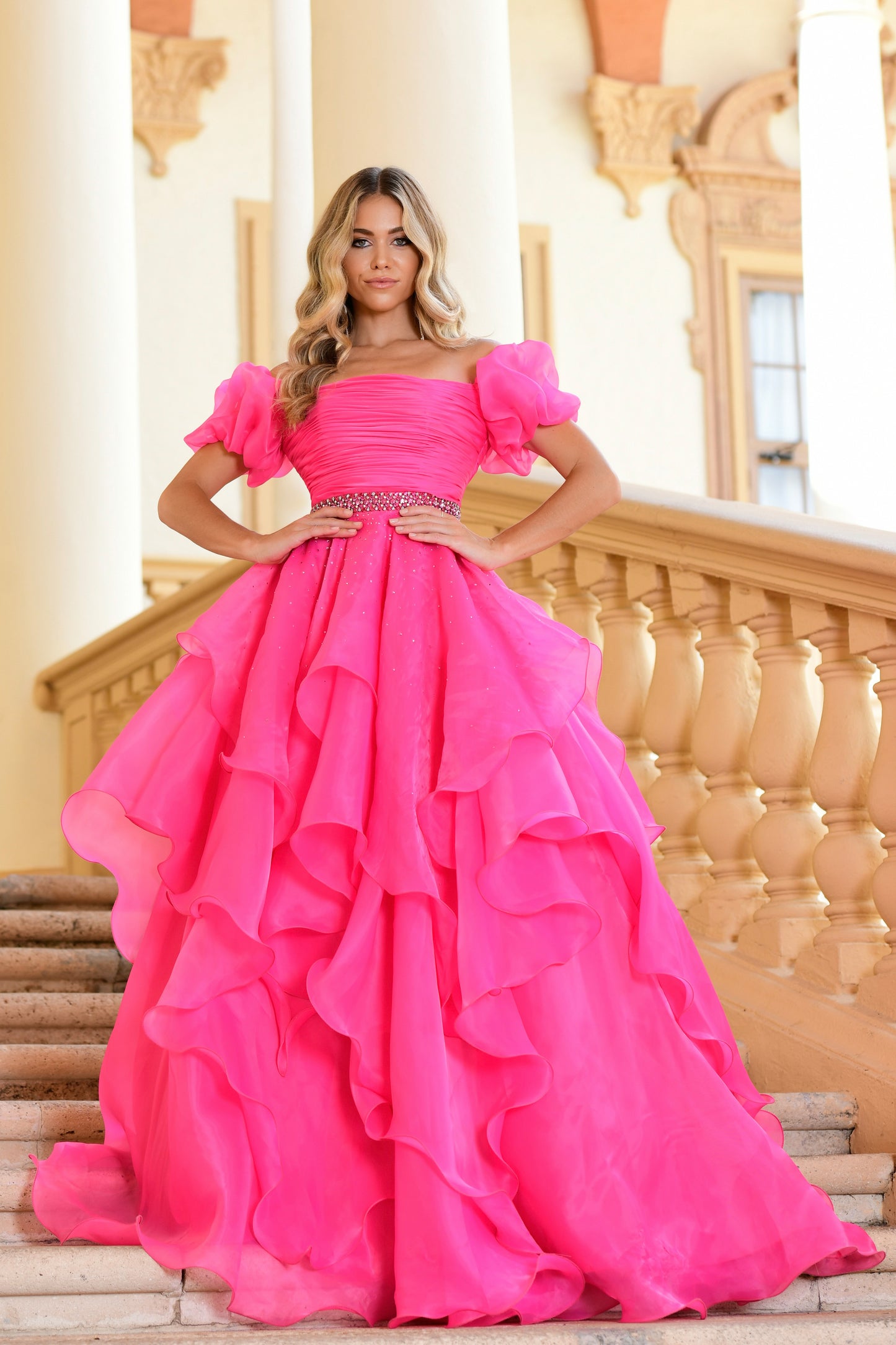 Introducing the Ava Presley 28571 Dress, perfect for any pageant or special occasion. It features a long ruffle ballgown style along with an off-the-shoulder, puff sleeve design. Crafted from a premium quality fabric, this gown is lightweight, durable, and provides a comfortable fit. Get ready to sparkle and shine in this gorgeous dress.  Sizes: 00-18  Colors: Black, Fuchsia, Light Blue, Red, Royal, White, Orchid