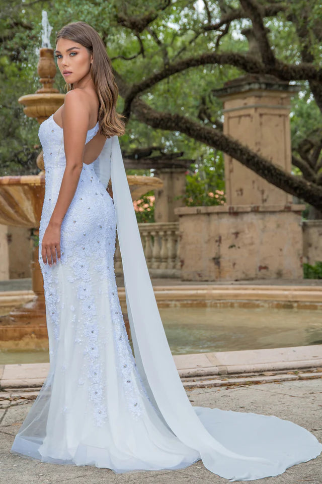 This stunning Ava Presley 28578 long prom dress features a one shoulder design with an intricate sequin pattern. The high slit and cape sleeve add a touch of elegance to this formal gown, making it perfect for any pageant or special occasion. Make a statement and stand out in style with Ava Presley.