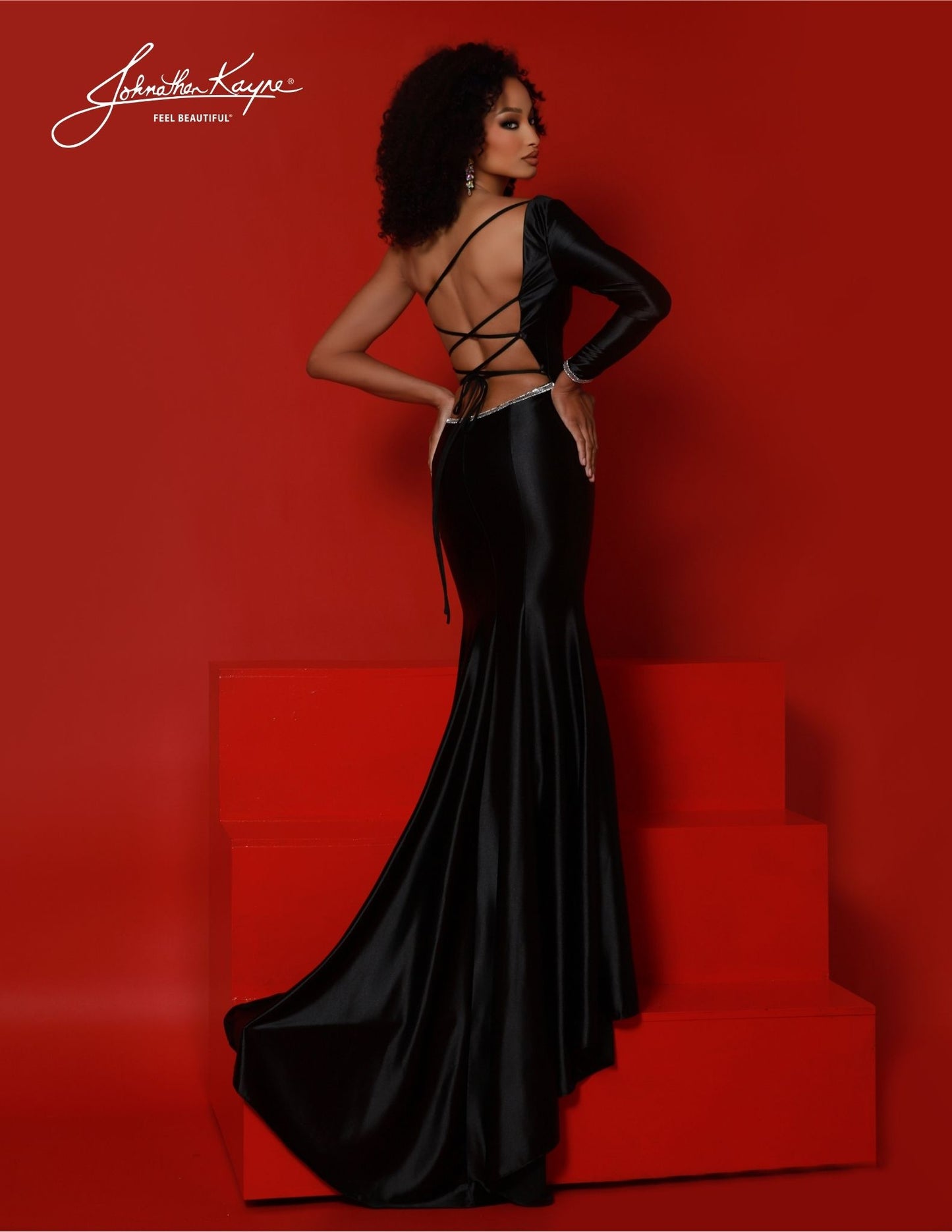 Johnathan Kayne 2859 is designed for an unforgettable look. The one-shoulder long sleeve fitted gown features a corset back and mermaid tail silhouette. Defined by intricate details and exquisite craftsmanship, this is the perfect dress for any special occasion. Get ready to dazzle, delight, and dominate the scene in this one-shoulder long sleeve gown. Crafted from Shiny 4 Way Stretch Lycra, this gown is truly a showstopper. The open corset back and thigh-high slit is sure to bring a dash of drama!