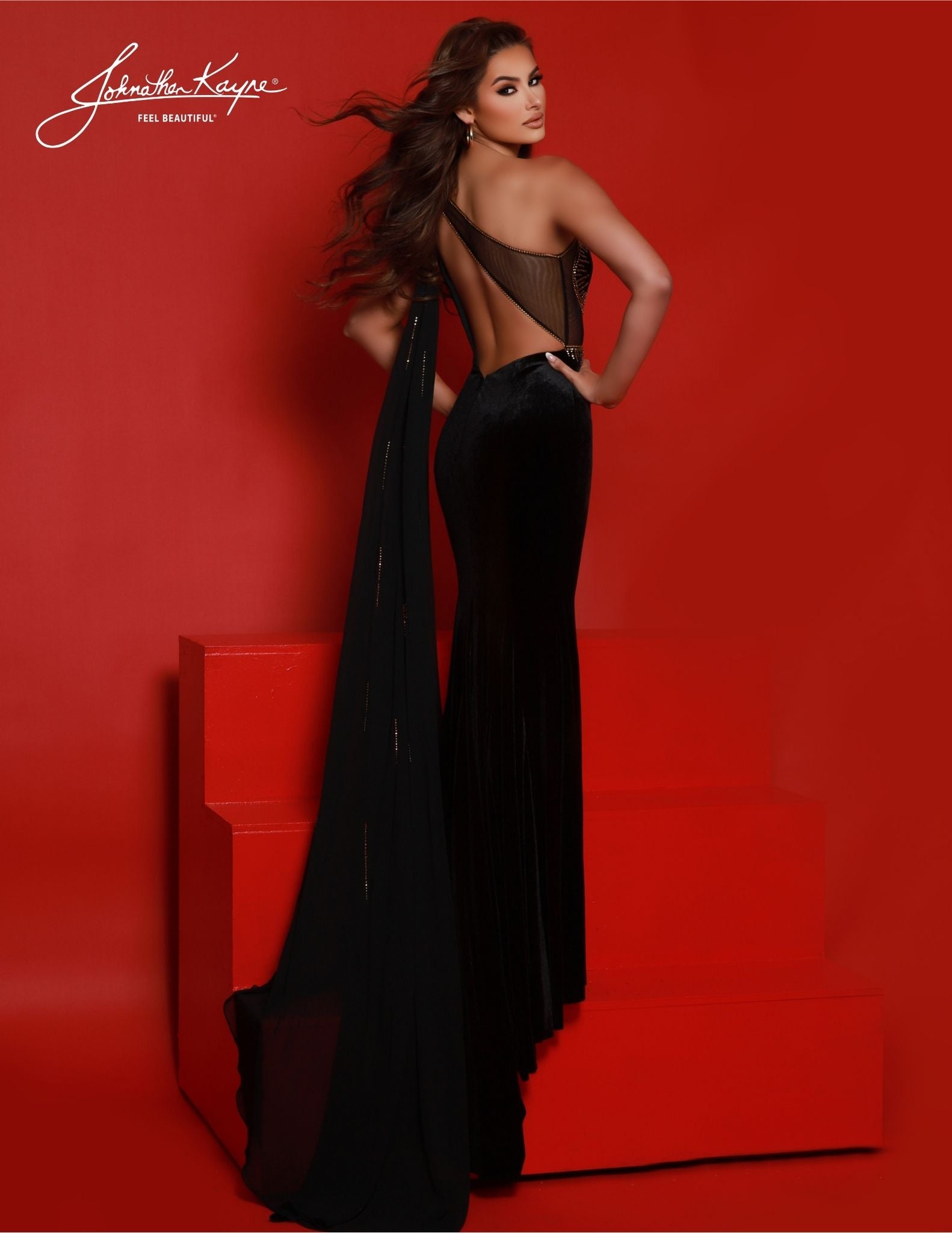 Johnathan Kayne's 2861 Long Prom Dress is a luxurious formal gown perfect for special occasions. Featuring a velvet one-shoulder design with a sheer cutout and detachable shoulder cape, this gown is sure to make an impact with its dramatic slit tail and form-fitting silhouette. Make a statement in this elegant velvet piece. Embrace your inner goddess in our one shoulder stretch velvet gown. 