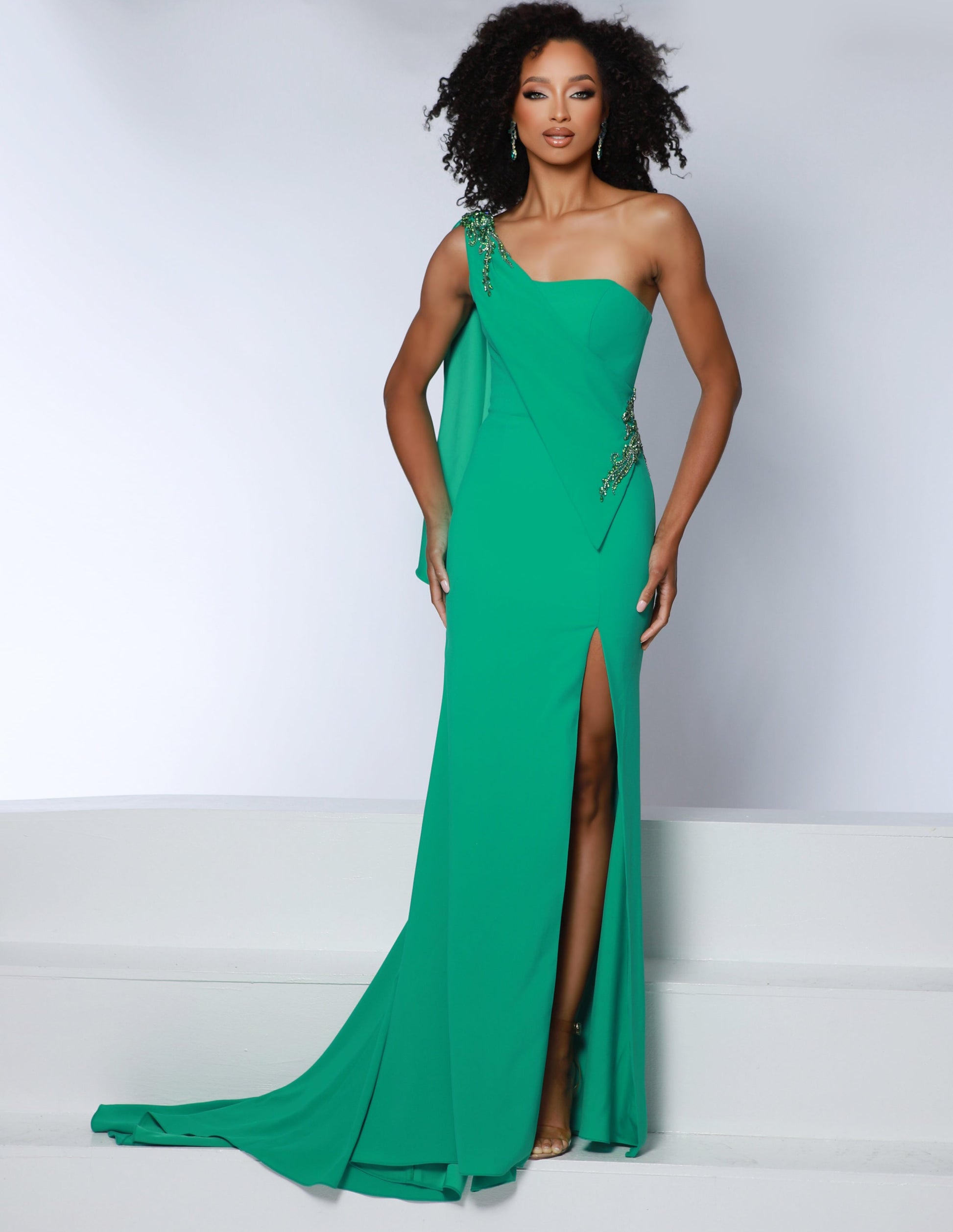 The Johnathan Kayne 2864 long prom dress features a one-shoulder silhouette and crepe fabric with encrusted crystals for an elegant look. The slit tail and high side slit add a touch of drama to make a lasting impression. This formal and pageant gown is perfect for special occasions. Get ready to take the crown in our one-shoulder stretch crepe gown. Adorned with stunning encrusted crystals on the one shoulder bodice and side, this gown is a regal masterpiece of style and grace. 