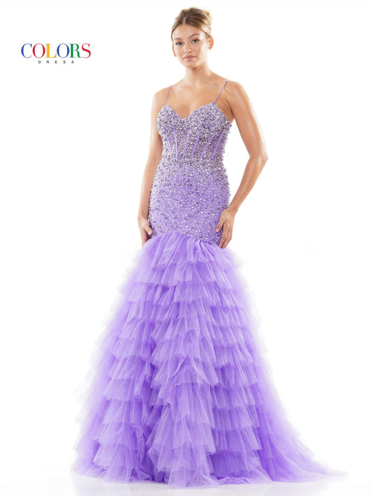 Slip into elegance with Colors Dress 3189. This stunning mermaid prom dress features a sheer beaded corset bodice, accentuating your curves and glittering with every move. The ruffle layered tulle skirt adds a touch of drama, while the V-neckline elongates your silhouette. Perfect for any formal event, this gown will make you feel confident and glamorous.  Sies: 0-22  Colors: Off White, Red, Lavender