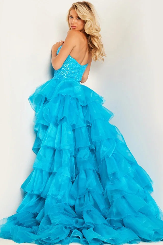 The Jovani 37689 is a captivating formal gown designed to make a lasting impression at special events. It combines sequin and tulle materials, resulting in a luxurious and dazzling look with the sequins adding a touch of glamour and the tulle imparting an ethereal quality. The dress is fitted, emphasizing the wearer's figure, and features an overskirt, creating a unique and captivating design.