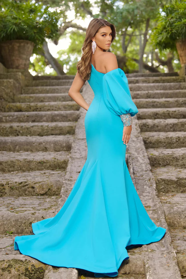 Expertly crafted by Ava Presley, this 38352 Long Prom Jersey Dress is the epitome of elegance. The one shoulder design and long puff sleeves add a touch of sophistication, while the crystal detailing and high slit mermaid silhouette make it a show-stopping formal choice. Perfect for pageants or any special occasion.