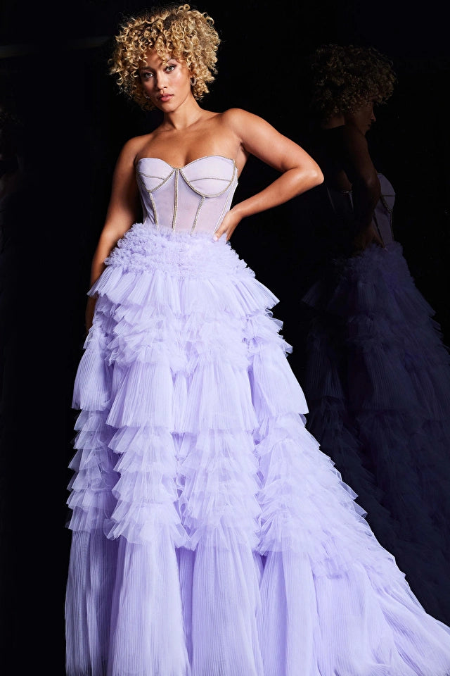 The Jovani 38539 is a stunning formal ballgown designed to make a glamorous and memorable statement at special occasions. Crafted from tulle, it features a multi-layered skirt that adds volume and creates a sense of opulence, characteristic of ballgown styles. The inclusion of a train adds grandeur and extravagance, making it ideal for formal events.  With a high waist, the gown accentuates the natural waistline, creating an elegant and flattering look. 