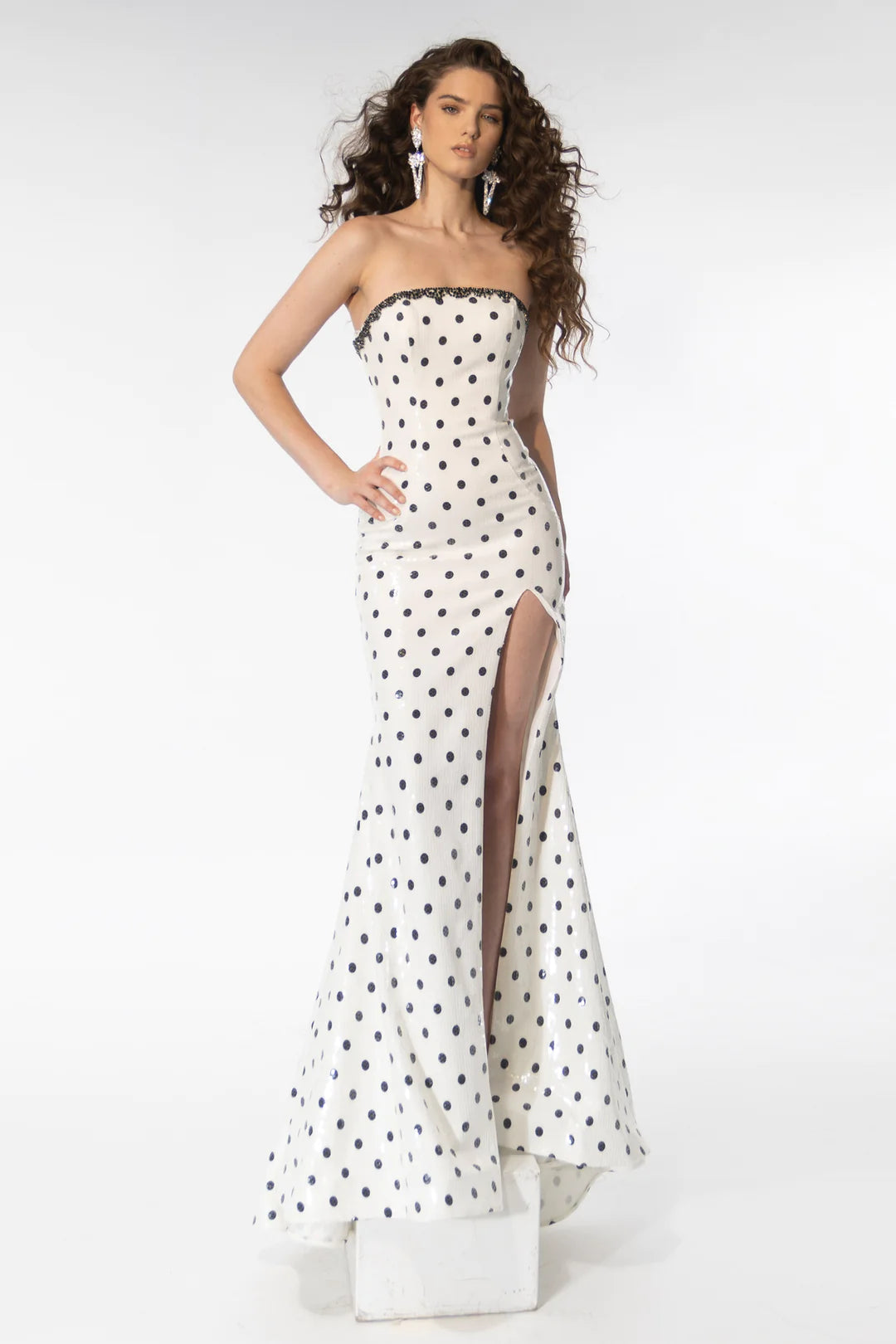 Dazzle the crowd in the stunning Ava Presley 39253 prom dress. Its strapless design and high slit add a touch of sophistication, while the sequin polka dot print and crystal detailing make it a showstopper. Be the belle of the ball in this formal gown.