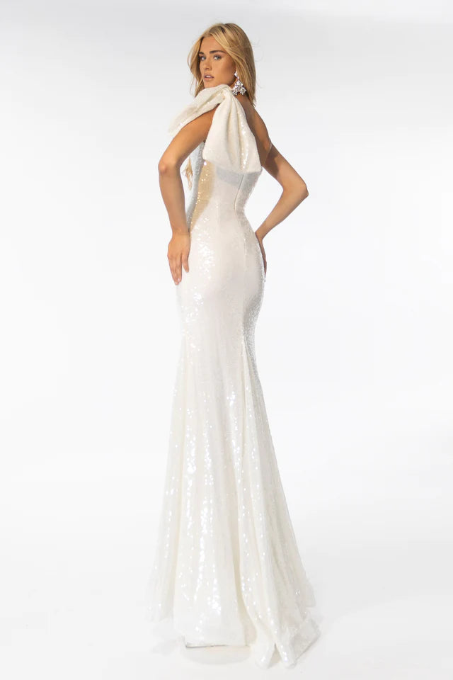Expertly crafted for elegant occasions, the Ava Presley 39286 Long Sequin Gown presents a captivating silhouette and stylish one shoulder bow detail. Dazzling sequins and a mermaid train add dramatic flair, making it the perfect choice for proms, formal events, and more.