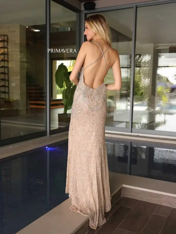 Indulge in luxury with the Primavera Couture 4109 Long Prom Dress. Embellished with sequins and a criss-cross open back, this gown exudes elegance. The fitted design flatters the figure while the high slit adds a touch of glamour. Perfect for formal events and pageants.