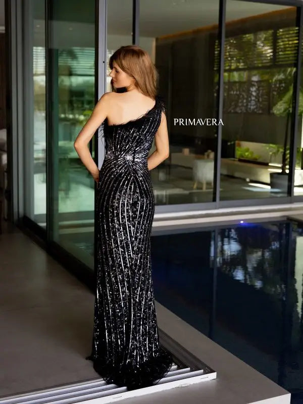 Elevate your style with the Primavera Couture 4112 long prom dress. This stunning gown features a one shoulder design with feathers, a high slit, and sequin details for a glamorous touch. Perfect for formal events, pageants, and more. Make a statement with this fitted and elegant gown.