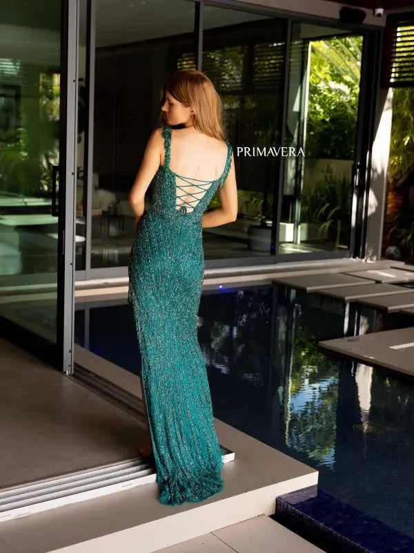 Step into the spotlight with the Primavera Couture 4127 Long Prom Dress. This stunning gown features a trendy off-shoulder neckline, a figure-flattering corset bodice, and intricate sequin and bead detailing. The fringe accents and high slit add a touch of glamour, making it the perfect choice for your next formal event or pageant.