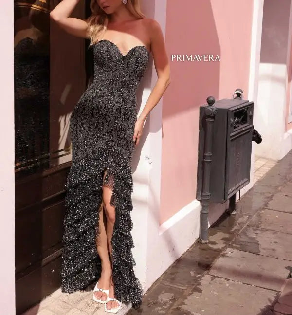 Elevate your formal attire with the stunning Primavera Couture 4128 long prom dress. This elegant gown features allover sequins, a fitted ruffle tiered design, and a strapless sweetheart neckline. Perfect for proms, pageants, or any special occasion. Make a statement in this truly exquisite and glamorous gown.