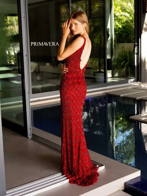 Slay the night in this stunning Primavera Couture 4129 Long Prom Dress. With fringes and sequins embellishing the tank straps and an open back, this formal pageant gown is sure to turn heads. The perfect combination of elegance and glamour for any special occasion.