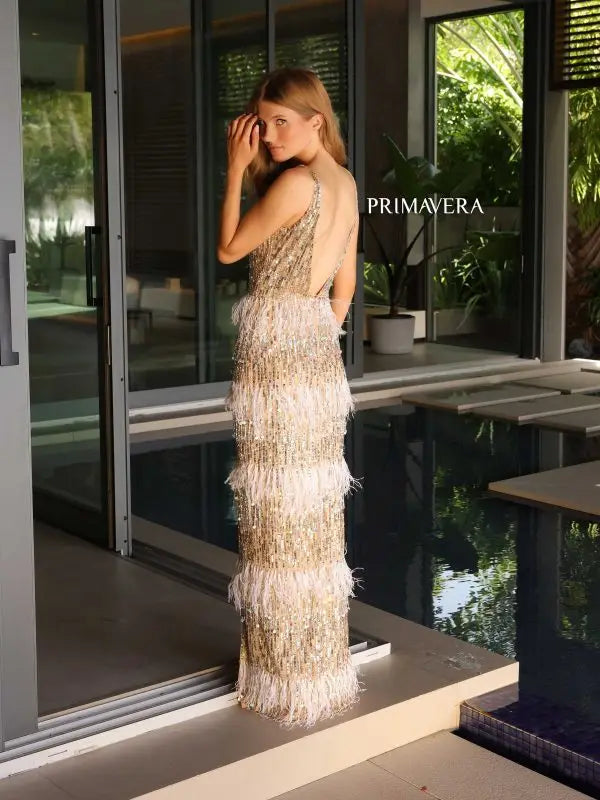 This Primavera Couture 4132 Long Prom Dress features a stunning V-neck, luxurious feather detailing, and a high slit for an alluring silhouette. The intricate sequins and open back add a touch of glamour to this formal pageant gown. Elevate your prom night with this elegant and eye-catching dress.